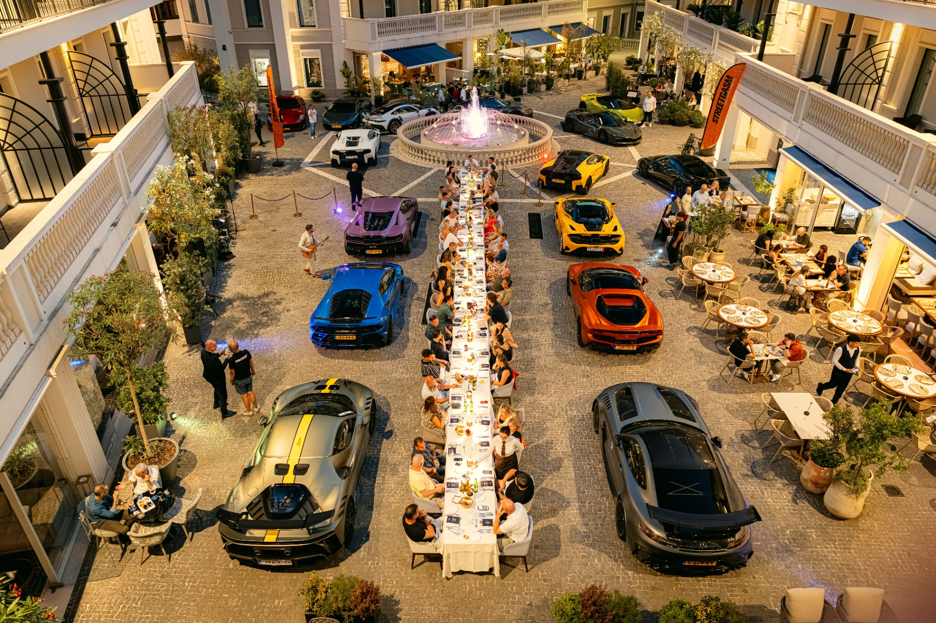 supercars bij lange tafel in italie